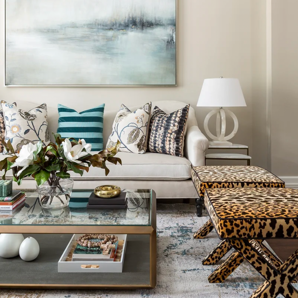 Living room decor in a neutral color palette, with plenty of pattens and texture in the throw pillows and ottomans.