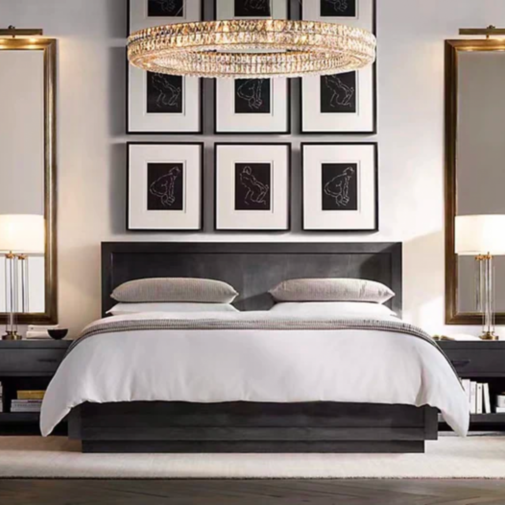 Modern interior design style bedroom with a black, low to the ground queen size bed.  Color palette is black and white with long brass mirrors above flanking nightstands.