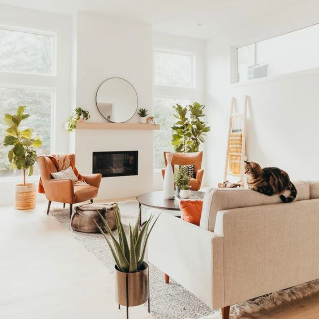 Scandinavian style living room with a minimalistic approach to the fireplace and sofa decor.  Leather armchairs exude warmth.  Room includes a natural ottoman and a wood latter decorative element.