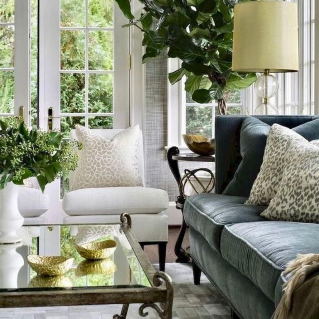 Transitional interior design style living room with a dark green and blue sofa, white armchairs and an ornate coffee table. 
